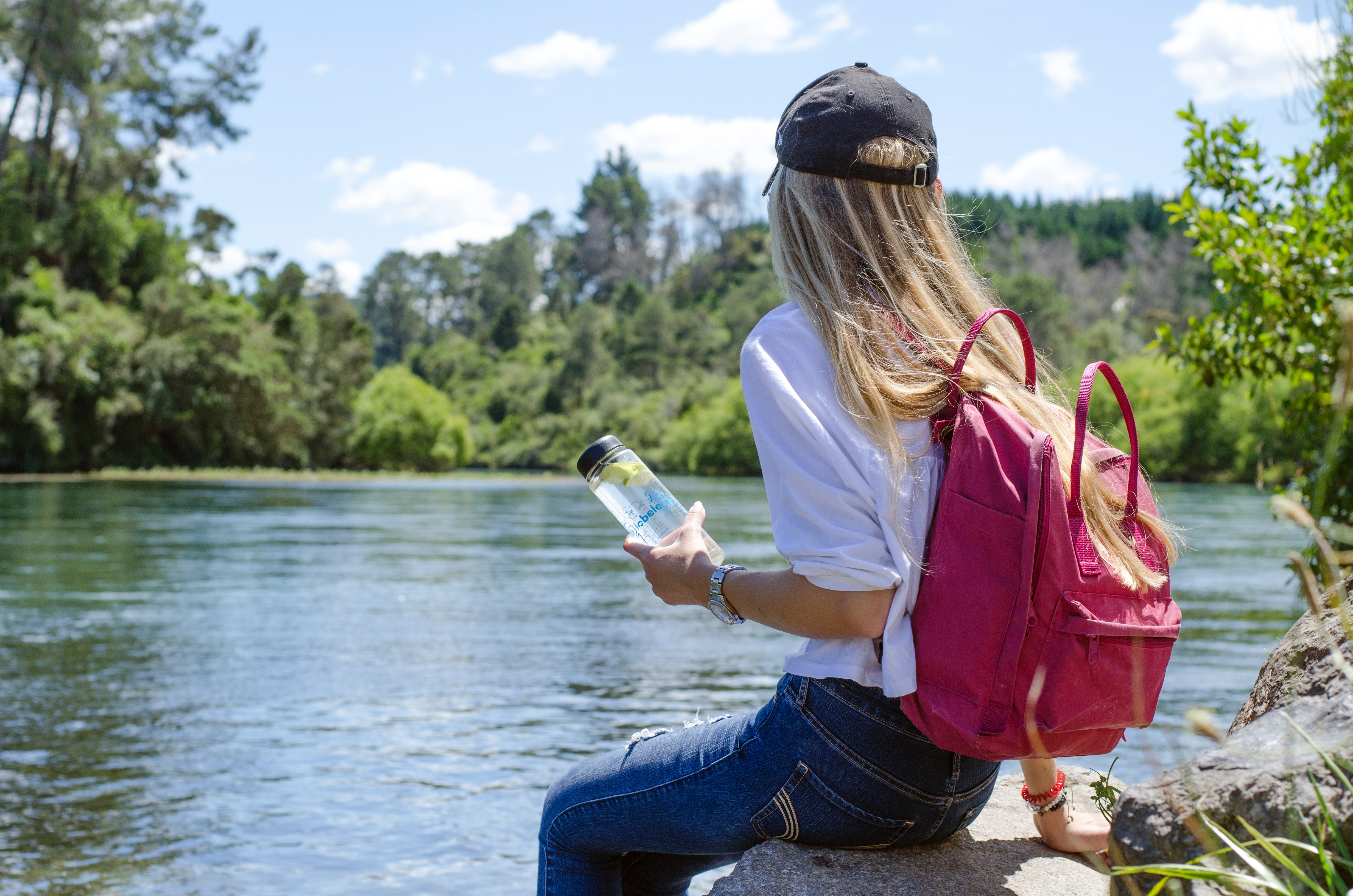 Woman holding water bottle by pond